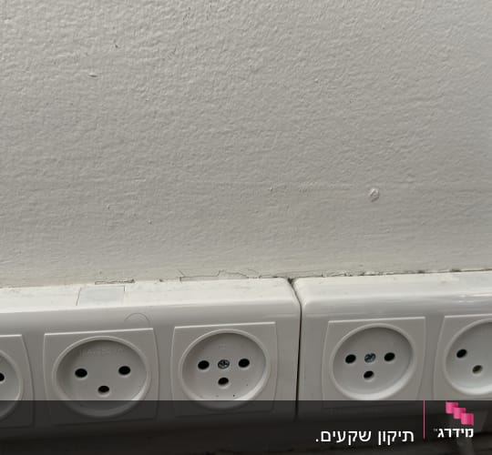 שישה שקעים חשמליים מותקנים על קיר לבן